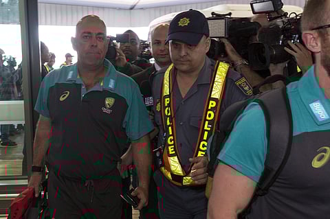 Australian cricket coach Darren Lehmann, left, arrives with his team at the Cape Town International airport as they depart to Johannesburg for the final five day cricket test match, in Cape Town, South Africa, Tuesday, March 27, 2018. | AP