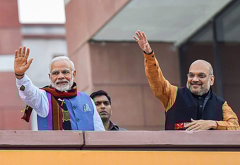 Prime Minister Narendra Modi and BJP President Amit Shah wave as they arrive to address BJP party workers after their victory in North-East Assembly election at party headquarters in New Delhi. (PTI)