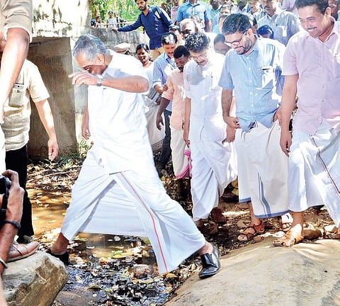 Chief Minister Pinarayi Vijayan crosses a stream to reach the house of Madhu at Chindakki in Attappadi on Friday