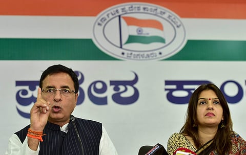 Congress leader and national media in-charge of the party Randeep Singh Surjewala speaks during a press conference as Congress spokesperson Priyanka Chaturvedi looks on at KPCC office in Bengaluru on Friday. | PTI