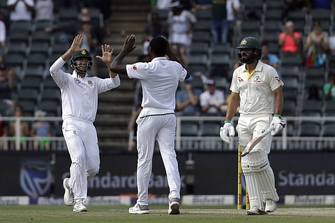 South Africa's Aiden Markram, left, celebrates with teammate Kagiso Rabada, middle for dismissing Australia's batsman Joe Burns for 4 runs on day three of the fourth cricket Test between South Africa and Australia at the Wanderers Stadium. | AP