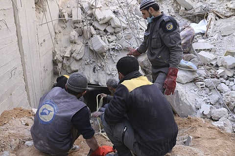 Syrian Civil Defense group members working to remove victims from under the rubble of a damaged shelter that was hit in airstrikes (Photo | AP)