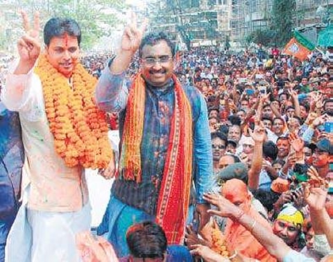 BJP leaders Ram Madhav and Biplab Kumar Deb flash the victory sign in Agartala on Saturday. (PTI)