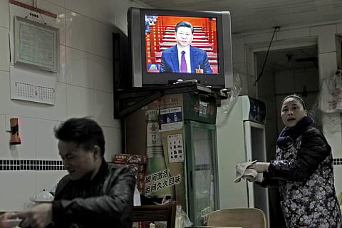 Chinese President Xi Jinping is shown on a news broadcast of the opening session of the National People's Congress in a restaurant in Shanghai, March 5, 2018. (AP Photo)