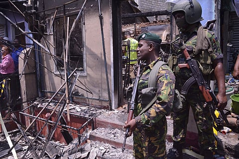 Sri Lanka's security forces stand near a vandalized building in Digana, a suburb of Kandy, Sri Lanka. | AP