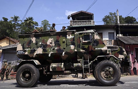 Sri Lankan army soldiers look on from an armed personnel carrier in Digana, a suburb of Kandy. | AP