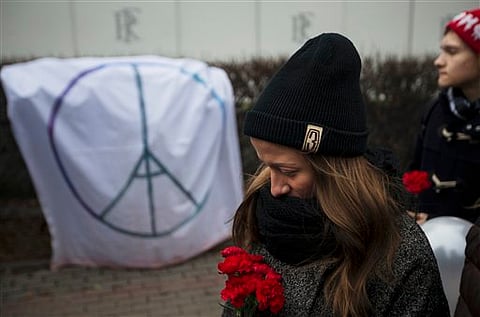 People line up to lay flowers in front of the French embassy in Moscow, Russia, Saturday, Nov. 14, 2015, for the victims of the Paris attacks on Friday. | AP
