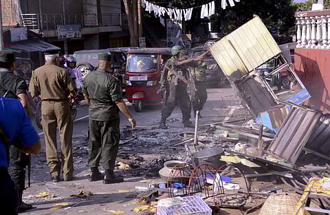 Sri Lanka's army soldiers remove the debris of a vandalized building in Digana, a suburb of Kandy. (Photo | AP)