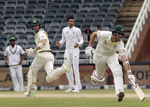 Australia's batsman Pat Cummins, right, avoids a run out as teammates Tim Paine, left, watches on during day three of the fourth cricket test match between South Africa and Australia. (Photo | AP)
