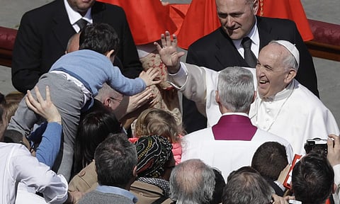 Pope Francis salutes a child after leading the Easter Mass in St. Peter Square at the Vatican. | AP