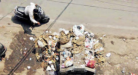 A man throwing waste near a bin overflowing with garbage at Shalibanda in Old City on Saturday | Sathya keerthi