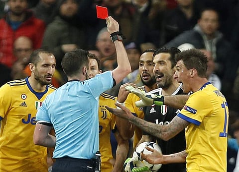 Referee Michael Oliver shows a red car to Juventus goalkeeper Gianluigi Buffon during a Champions League quarter final second leg soccer match between Real Madrid and Juventus at the Santiago Bernabeu stadium in Madrid, Wednesday, April 11, 2018. | AP
