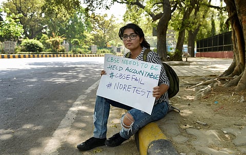 A 10th class CBSE student displays a placard during a protest over the alleged paper leak at Jantar Mantar in New Delhi. (File | PTI)