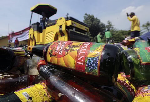 Government officials destroy bottles of illegal alcohol confiscated in Serpong, on the outskirts of Jakarta, Indonesia Friday, April 13, 2018. | AP
