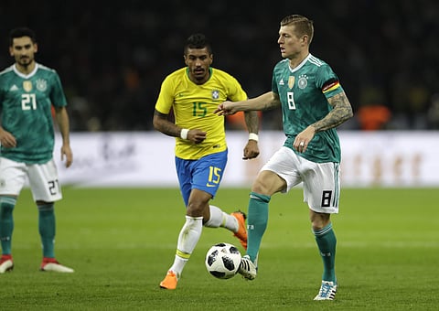 Germany's Toni Kroos, left, is challenged by Brazil's Paulinho, center, during the international friendly soccer match between Germany and Brazil in Berlin, Germany, Tuesday, March 27, 2018. | AP