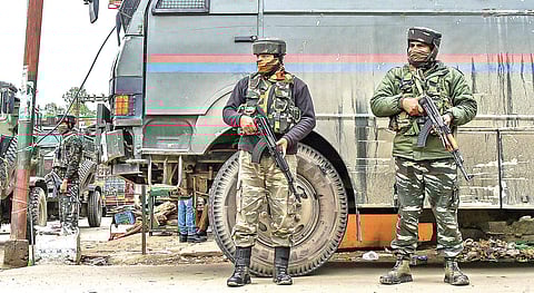 Security men stand guard during a recent encounter in Khudwani, Kulgam;