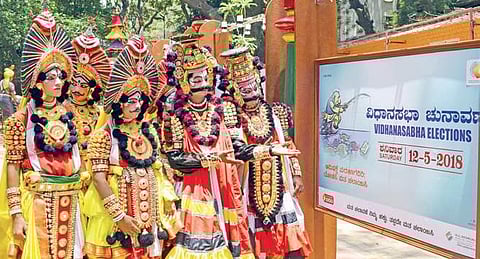 Yakshagana artistes having a look at a hoarding during an election awareness exhibition held at Press Club in Bengaluru on Saturday | Pandarinath B