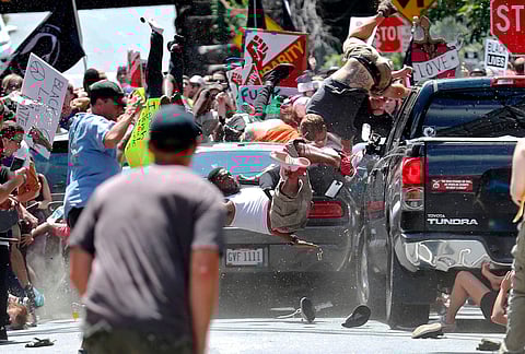 In this August 12, 2017 Pulitzer Prize-winning photo by Ryan Kelly of The Daily Progres, people fly into the air as a car drives into a group of protesters demonstrating against a white nationalist rally in Charlottesville (AP)