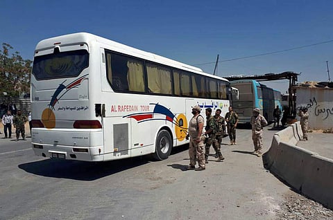 Syrian government forces overseeing the evacuation by bus of Army of Islam fighters | AP