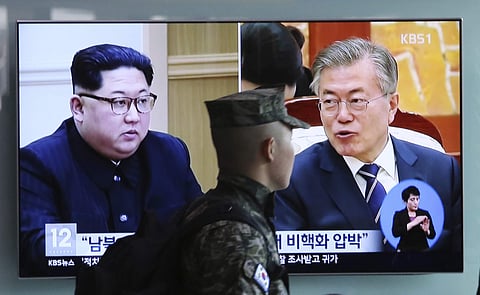 A TV screen showing file footage of S.Korea President Moon Jae-in and N.Korea leader Kim Jong Un, left, during a news program (Photo| AP)