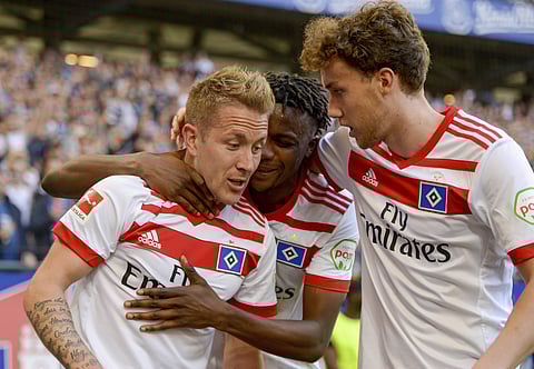 Hamburg's Lewis Holtby, left, Gideon Jung, center, and Luca Waldschmidt celebrate the opening goal during the German Bundesliga soccer match between Hamburger SV and SC Freiburg, in Hamburg, Germany, Saturday, April 21, 2018. (AP)