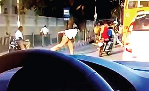 A video grab shows a traffic constable throwing a shoe at students on BEL Road for not wearing helmets