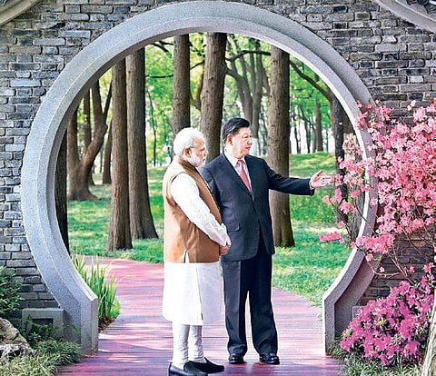 Prime Minister Narendra Modi and Chinese President Xi Jinping talk at a garden in Wuhan in central China’s Hubei Province on Saturday | AP/PTI