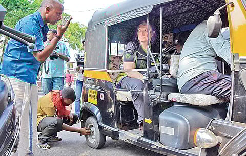 A worker supporting the 24-hour general strike forcefully lets off air from the tyre of an autorickshaw carrying foreign tourists at Thampanoor in Thiruvananthapuram on Monday. As the police remained mute spectators, Austrian tourists Tiefengrabererika an