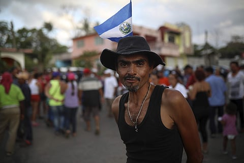 Eduardo Claro of El Salvador wears his country's flag on his hat as Central American migrants traveling with the annual Stations of the Cross caravan march for migrants' rights and protest the policies of U.S. President Donald Trump and Honduran President