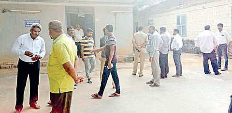 People wait outside the mortuary in Kundapur where the body of Sandeep was kept for postmortem on Saturday