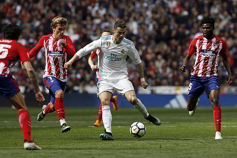 Real Madrid's Cristiano Ronaldo, centre, vies for the ball with Atletico Madrid's Antoine Griezmann, left, during the Spanish La Liga soccer match between Real Madrid and Atletico Madrid at the Santiago Bernabeu stadium. | AP
