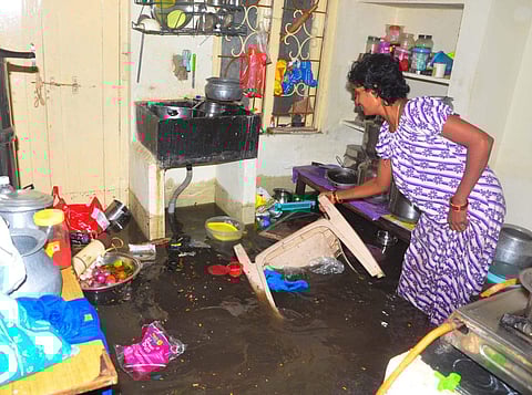 A woman's kitchen is inundated with unseasonal monsoon rain in Visakhapatnam on Tuesday. (G Satyanarayana)