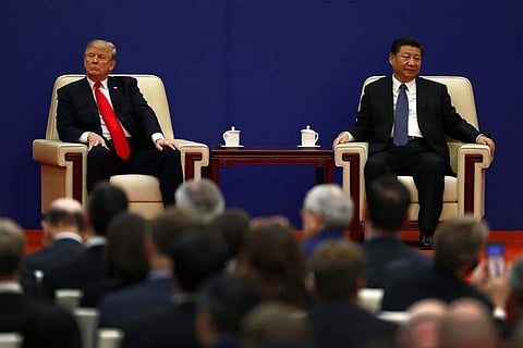 U.S. President Donald Trump, left, sits next to Chinese President Xi Jinping during a business event at the Great Hall of the People in Beijing. (Photo | AP)