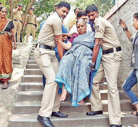Policemen carry a senior citizen to a polling booth due to the absence of a wheelchair or ramp at Padmanabhanagar in Bengaluru on Saturday | Nagaraja Gadekal