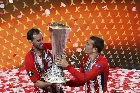 Atletico's Diego Godin, left, and Antoine Griezmann lift up the cup after the Europa League Final soccer match between Marseille and Atletico Madrid at the Stade de Lyon outside Lyon, France. | AP