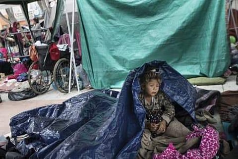A girl who traveled with the annual caravan of Central American migrants awakens where the group set up camp to wait for access to request asylum in the U.S. (Photo | AP)