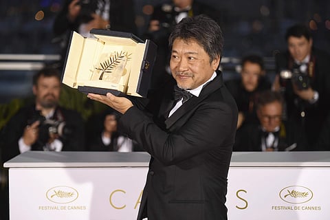 Director Hirokazu Kore-eda holds the Palme d'Or for the film 'Shoplifters' following the awards ceremony at the 71st international film festival, Cannes, southern France, Saturday, May 19, 2018. (AP Photo)
