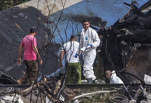Forensic investigators and Ministry of Interior officers sift through the remains of a Boeing 737 that plummeted into a yuca field with more than 100 passengers on board, in Havana, Cuba. | AP