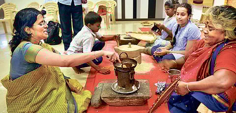 Nalina Kannan (L); Kaliambal (R) demonstrate the use of the kitchen tools