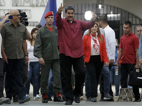 Venezuela's President Nicolas Maduro makes the victory sign after voting in presidential elections in Caracas, Venezuela, Sunday, May 20, 2018. | AP