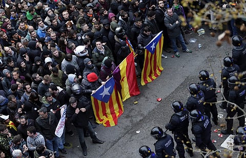 FILE: Catalan Mossos d'Esquadra regional police officers block the way to protestors, holding pro-independence and republican flags, trying to reach the Spanish government office in Barcelona. | AP