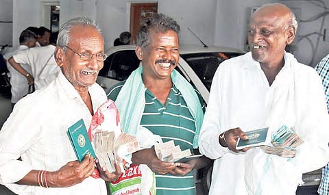 Beneficiaries grin after encashing the cheques they received under Rythu Bandhu scheme in Karimnagar | Express photo