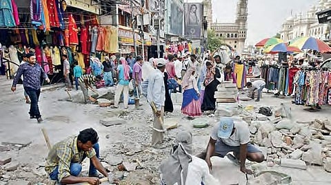 GHMC workers carry out road repair works near Charminar on Monday| vinay madapu