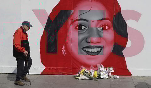 A man walks past a mural showing Savita Halappanavar, a 31-year-old Indian dentist who had sought and been denied an abortion before she died after a miscarriage in a Galway hospital, with the word YES over it, in Dublin, Ireland, on the day of a referend