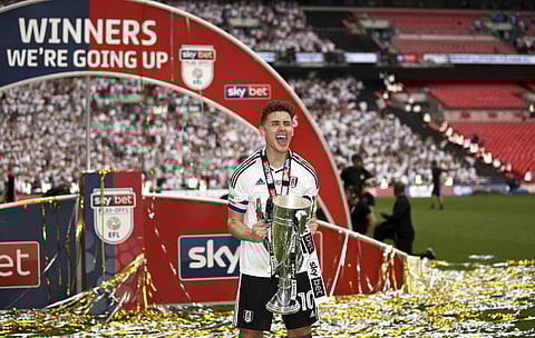 Fulham's Tom Cairney, centre, holds the trophy after the final soccer match of the English League Championship against Aston Villa, at Wembley Stadium, in London, Saturday May 26, 2018. | AP