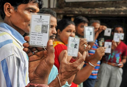 Voters show their Election Commission cards as they queue to cast their vote at a polling station during Maheshtala Assembly by-election at Maheshtala in South 24 Parganas district of West Bengal on Monday. (PTI)