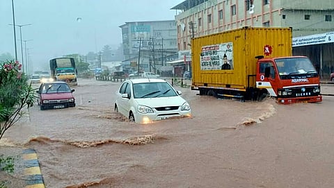 Vehicles wade through an inundated road as heavy rains hit Mangaluru. (EPS | Rajesh Shetty Ballalbag)