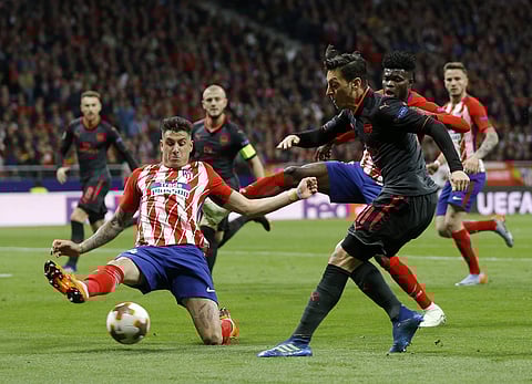 Arsenal's Mesut Ozil, right, duels for the ball with Atletico's Jose Maria Gimenez during the Europa League semifinal (File Photo | AP)