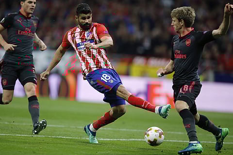 Atletico's Diego Costa fights for the ball against Arsenal's Nacho Monreal during the Europa League semi final, second leg soccer match between Atletico Madrid and Arsenal. (AP)