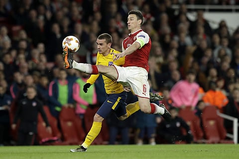 Arsenal's Laurent Koscielny, right, tries to stop Atletico's Antoine Griezmann during the Europa League semifinal first leg soccer match between Arsenal FC and Atletico Madrid at Emirates Stadium in London, Thursday, April 26, 2018. | AP